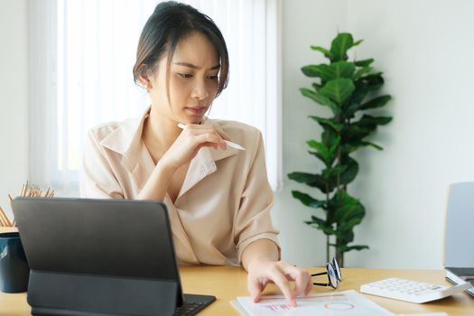 new normal, a businesswoman using tablet to work for a company Via the internet on your desk at home