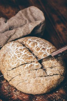 Sliced homemade rye bread on cutting board with knife