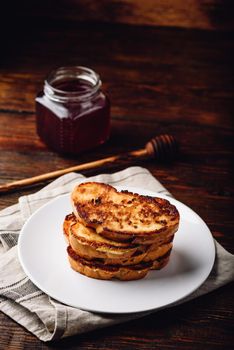 French toasts on white plate over wooden surface