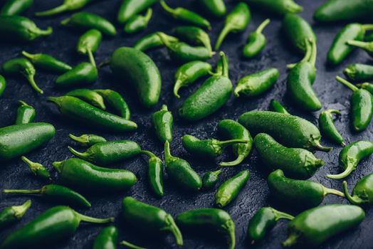 Close Up of Green Jalapeno Peppers on Black Concrete Background