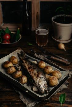 Baked Sea Bass Stuffed with Sorrel and New Potatoes on Baking Tray