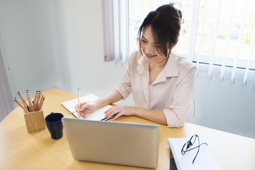 new normal, a businesswoman uses a computer to work for a company Via the internet on your desk at home.