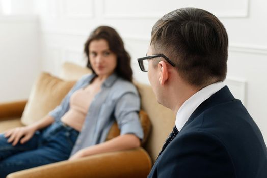 A male psychologist listens attentively to a female patient