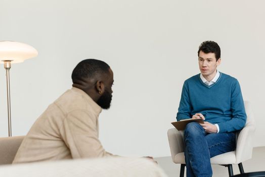 An African-American man talks to a psychologist about his problems. Psychological help service