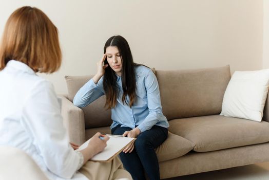 Beautiful young woman discussing her problems with female psychologist. Support and care.