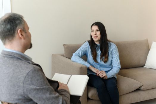 A young woman talks about her problems to a man psychologist. The concept of mental disorders