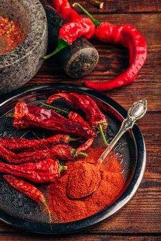 Spoonful of chili pepper powder with fresh and dried peppers