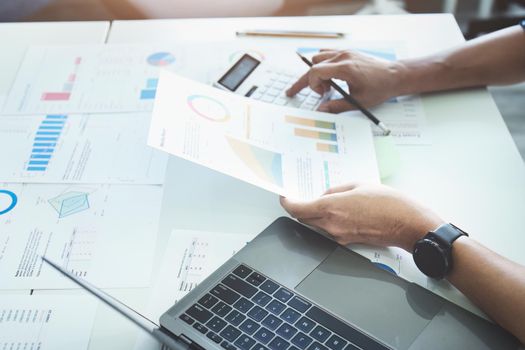 businessman hands using a calculator to check company finances and earnings and budget. calculating monthly expenses, managing budget, papers, loan documents, invoices concepts.