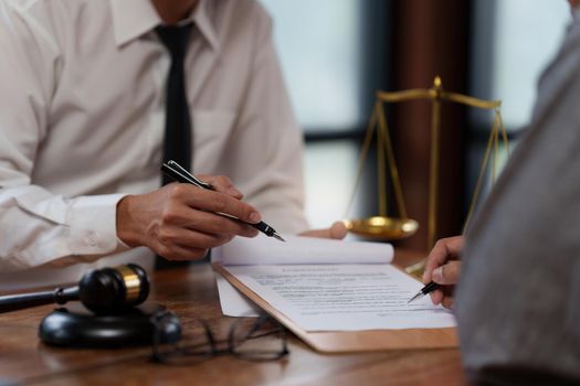 Business woman and lawyers discussing contract papers with brass scale on wooden desk in office. Law, legal services, advice, Justice concept