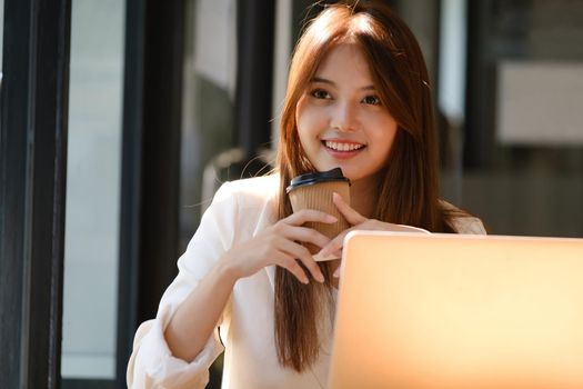 Happy businesswoman relaxing at office desk.