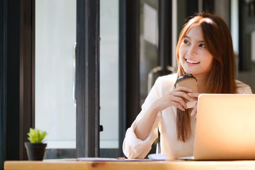 Happy businesswoman relaxing at office desk.