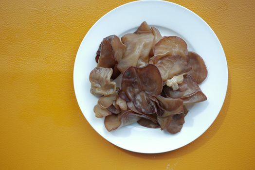 black fungus on a plate on orange background ,