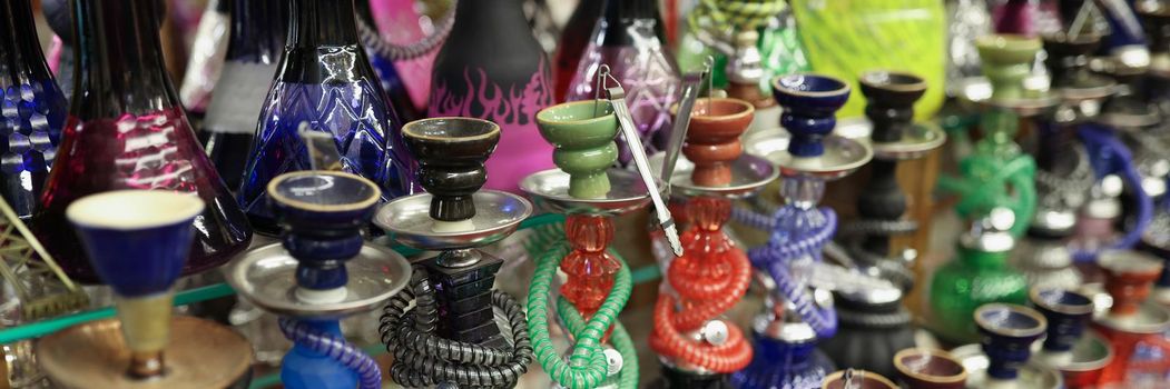 Close-up of traditional arabic shisha hookah pipes for sell on street market. Dozens of hookahs to smoke specially made tobacco. Local store, shop concept