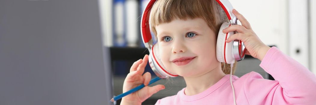 Portrait of little girl watch cartoon on laptop, smiling kid wear headset, fun pastime for child. Childhood, leisure, development, preschool class concept