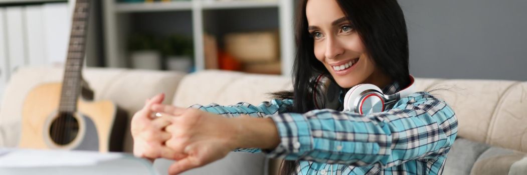 Portrait of smiling brunette woman warm up before playing on piano instrument. Inspired artist wear headset, learn new musical composition. Hobby concept