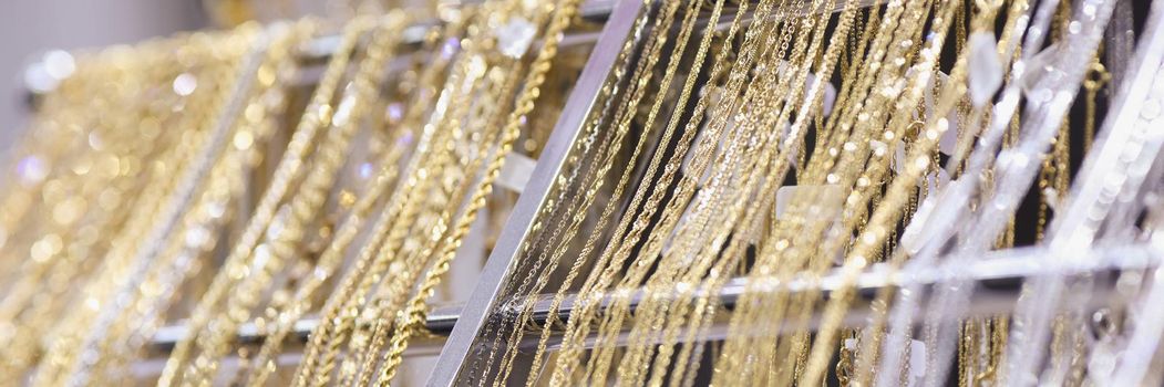Close-up of elegant gold and silver chain necklaces for sale in jewelry store. Set of recommend products for costumers. Beauty, luxury, shop, sale concept