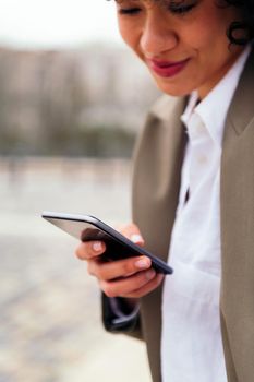 detail of the hand of a young latin woman using a mobile phone, concept of communication and urban lifestyle, copy space for text