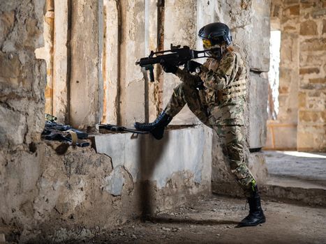 A woman in an army uniform shoots a firearm in an abandoned building