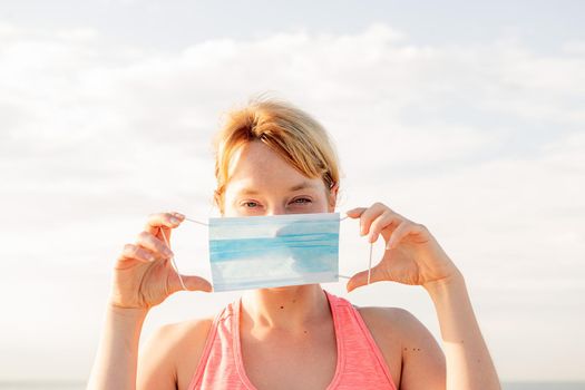 portrait of a beautiful blonde woman with a protective mask with the sky in the background, concept of prevention and health care, copy space for text