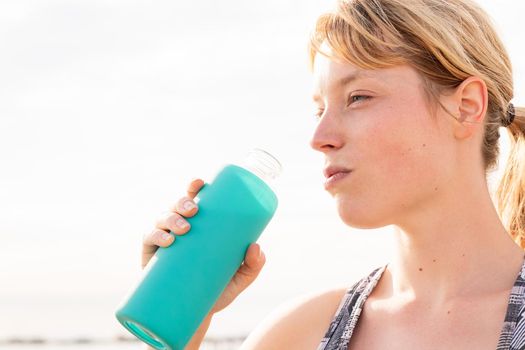 portrait of a sportswoman with a bottle of water, healthy lifestyle and sports concept, copy space for text