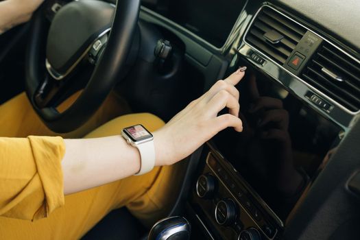 Unrecognizable female woman hand touching, clicking, tapping, sliding, dragging and swiping on screen monitor on modern luxury car. Interface concept