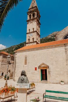 Historic city of Perast at Bay of Kotor in summer, Montenegro. Scenic panorama view of the historic town of Perast at famous Bay of Kotor with blooming flowers on a beautiful sunny day with blue sky and clouds in summer, Montenegro, southern Europe