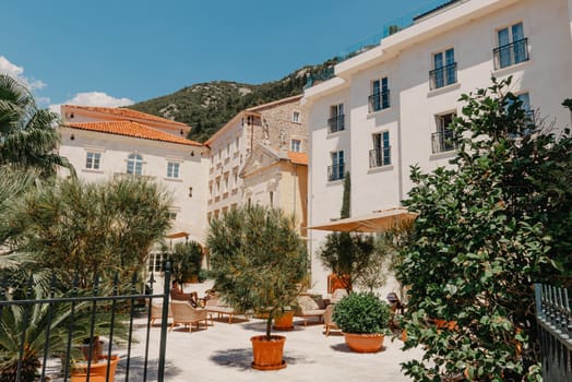 Historic city of Perast at Bay of Kotor in summer, Montenegro. Scenic panorama view of the historic town of Perast at famous Bay of Kotor with blooming flowers on a beautiful sunny day with blue sky and clouds in summer, Montenegro, southern Europe