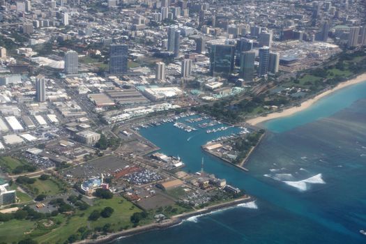 Aerial view of Kewalo Basin Harbor, Kakaako, Ala Moana Beach park in Honolulu with mall and Condo towers surrounding on a beautiful day in Oahu, Hawaii.