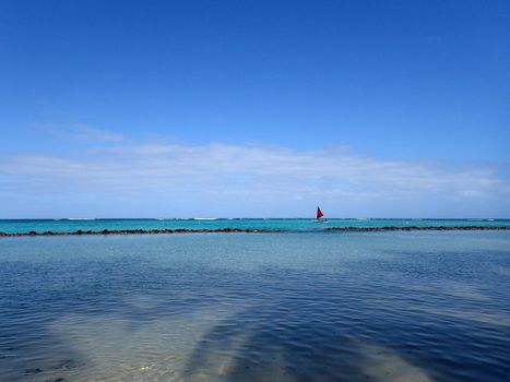 Pahonu Pond (Ancient Hawaiian Fishpond) with Shallow wavy ocean waters of Waimanalo bay looking into the pacific ocean with a blue sky full of clouds on Windward Oahu 2014.