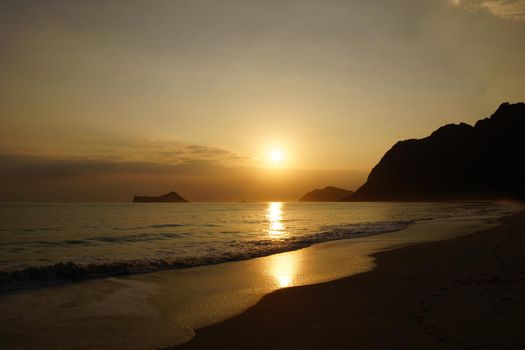 Early Morning Sunrise on Waimanalo Beach on Oahu, Hawaii over Rabbit and Rock Island over the clouds.