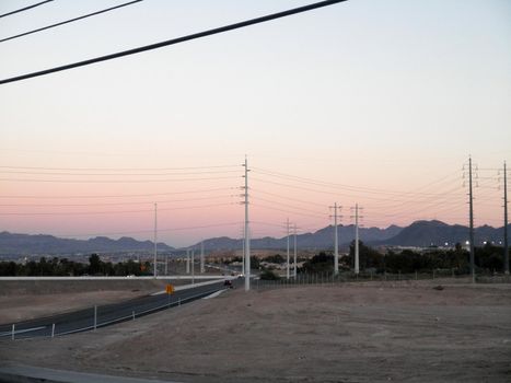 High Voltage Power-lines and Highway on-ramp at dusk in Las Vegas, Nevada.