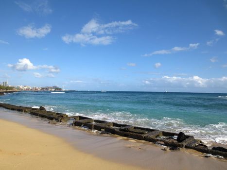 Old military water break on Sand Island Beach with Downtown Honolulu in the distance on Oahu, Hawaii