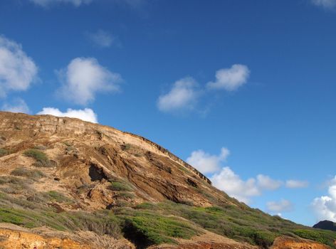 Close-up of top of Koko Head Mountain with blue sky with clouds visible on Oahu, Hawaii.  