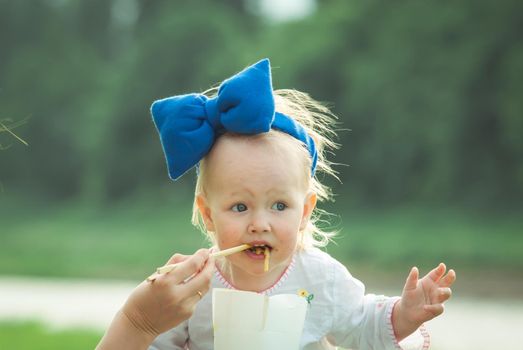 kid is eating thai food on nature background at sunset. High quality photo