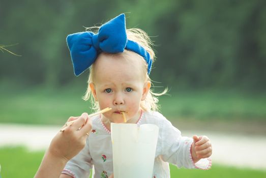 kid is eating thai food on nature background at sunset. High quality photo