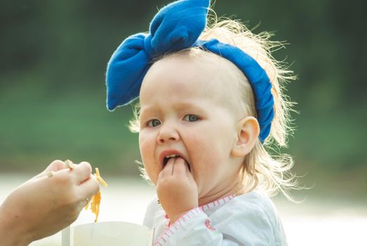 cute baby gilr is eating thai food outdoor. High quality photo