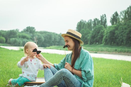 Mother is playing with baby girl in the park. High quality photo