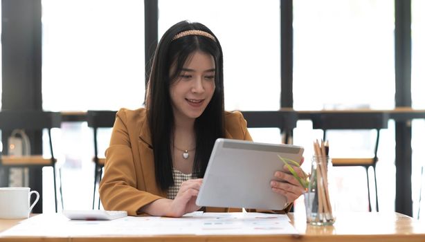 Asian attractive businesswomen using Digital Tablet standing in the office.