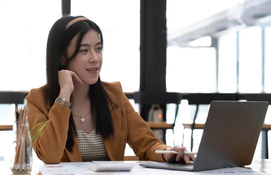 Portrait of smiling beautiful business asian woman working in modern office desk using tablet laptop computer, Business people employee freelance online marketing e-commerce telemarketing concept..