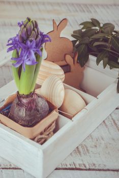 Easter decoration with wooden eggs, rabitts and flowers in box