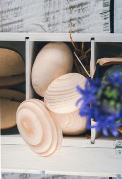 Easter decoration with wooden eggs, rabitts and flowers in box