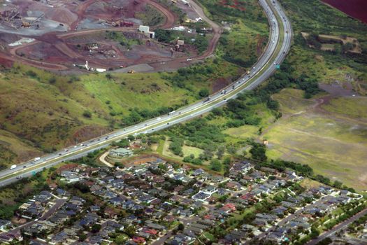 Aerial H-1 Interstate Highway running through Countryside into Kapolei city and construction site on Oahu, Hawaii.