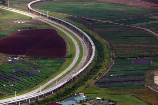 Aerial HART Rail system under construction and Highway next to each other in Kapolei city on Oahu, Hawaii.