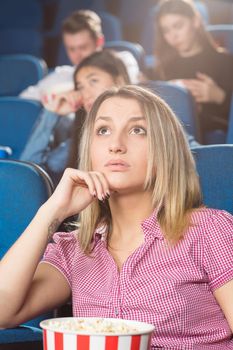Time for drama. Young beautiful woman watching drama movie looking sad at the movie theatre