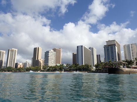 Waves lap towards Queens Beach and pier in Waikiki with Hotels in the distance.  Seen from water November 8, 2015.  