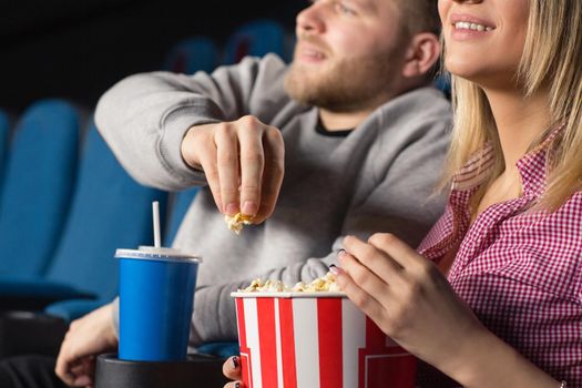 Loving the movie. Cropped closeup of a happy smiling couple eating popcorn at the movies
