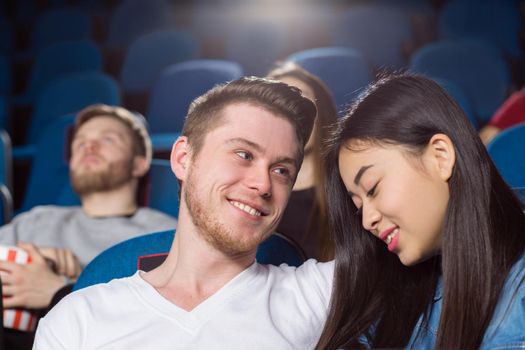 Enjoying our day. Low angle closeup of a beautiful loving couple at the cinema happy man looking at his smiling girlfriend with love