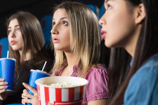 Friends out. Closeup shot of a beautiful female friends watching breathtaking interesting movie together at the cinema