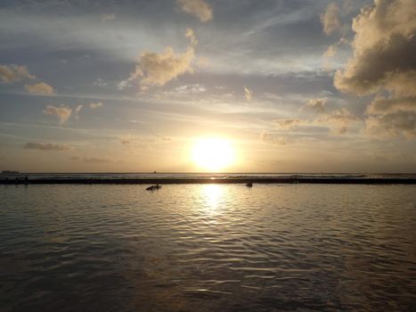 Dramatic Sunset on waters of Waikiki with boats on Horizon on Oahu, Hawaii.