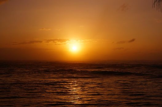 Beautiful Sunset over the ocean with waves moving to shore on the North Shore of Oahu.    